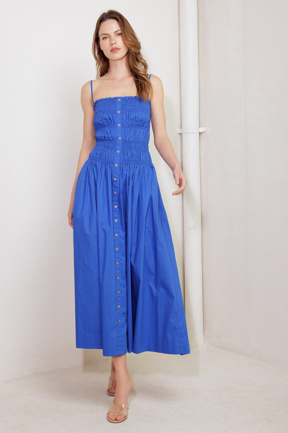 A solid blue woven midi dress featuring straight neckline, straps, button down detail and smocked bodice