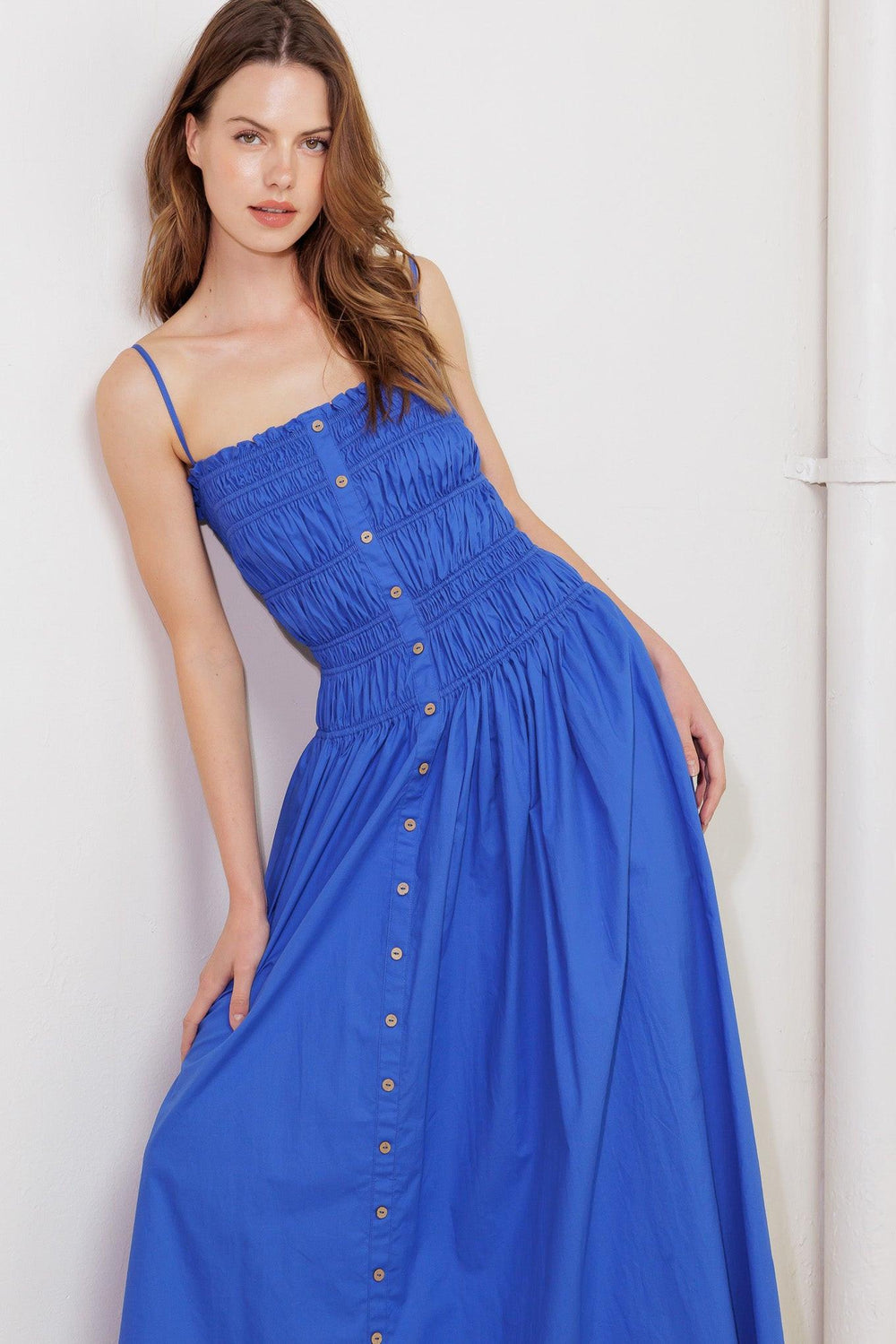 A solid blue woven midi dress featuring straight neckline, straps, button down detail and smocked bodice