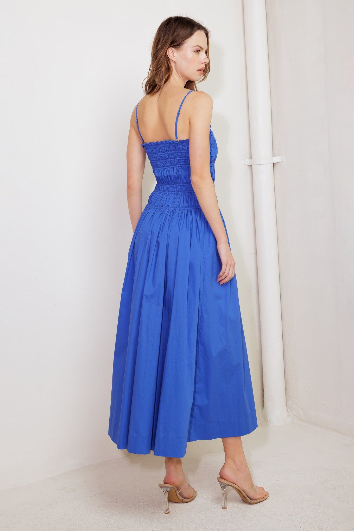 A solid blue woven midi dress featuring straight neckline, straps, button down detail and smocked bodice