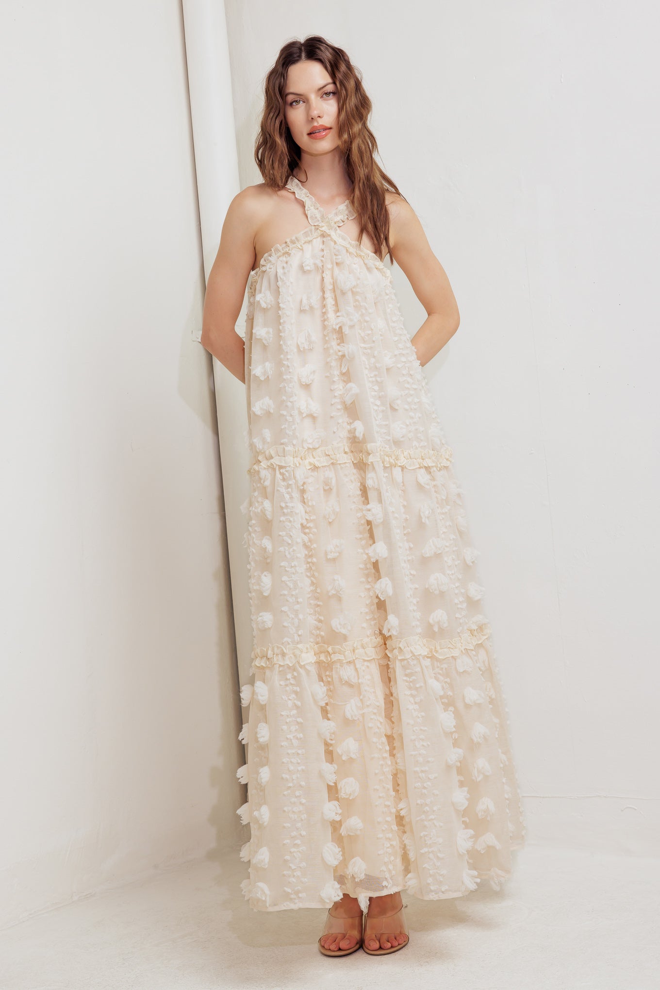 A textured woven ankle dress featuring ruffled cross front and tiered skirt