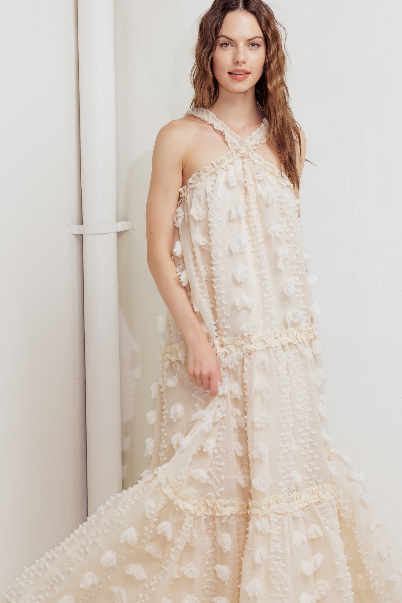 A textured woven ankle dress featuring ruffled cross front and tiered skirt