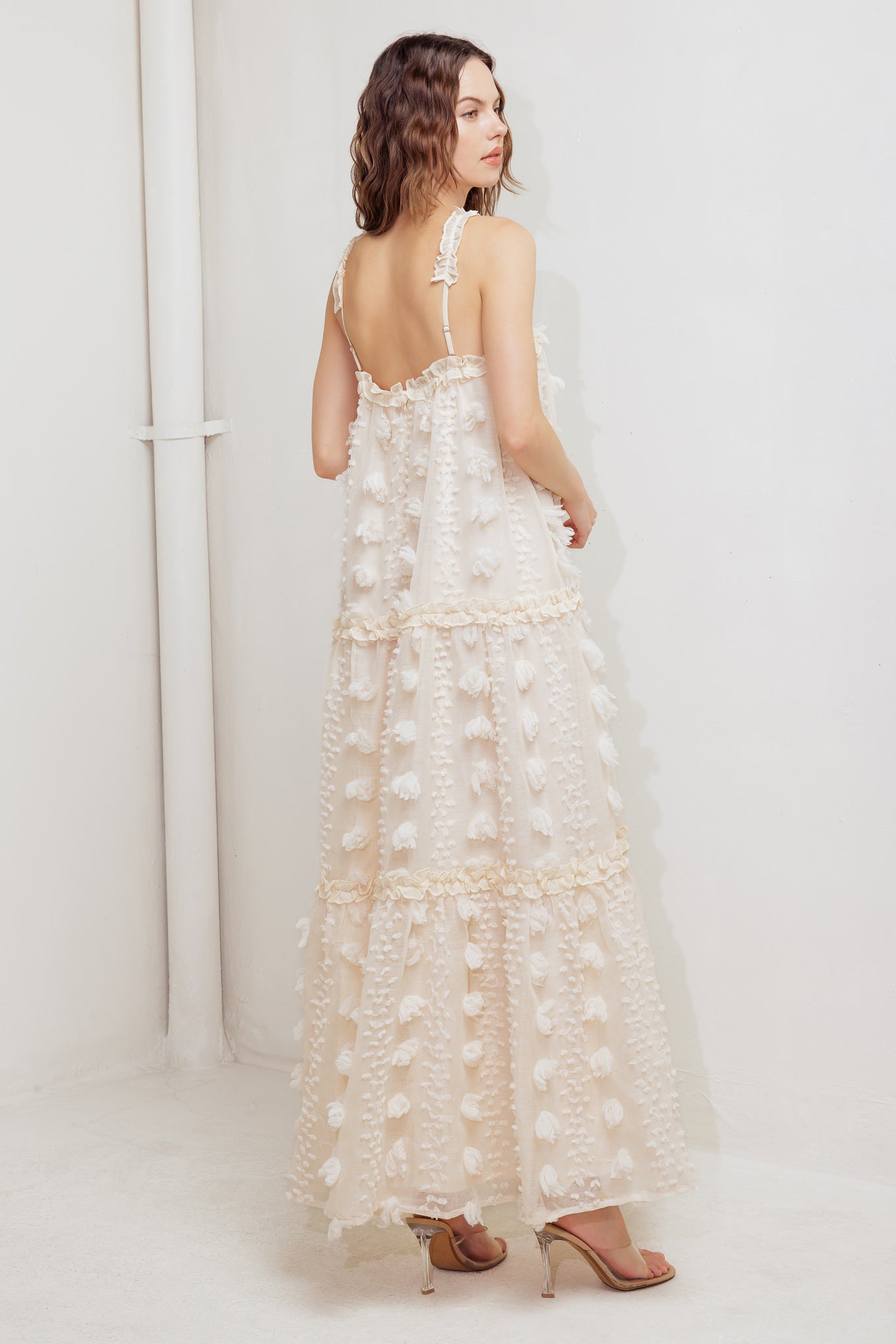 A textured woven ankle dress featuring ruffled cross front and tiered skirt