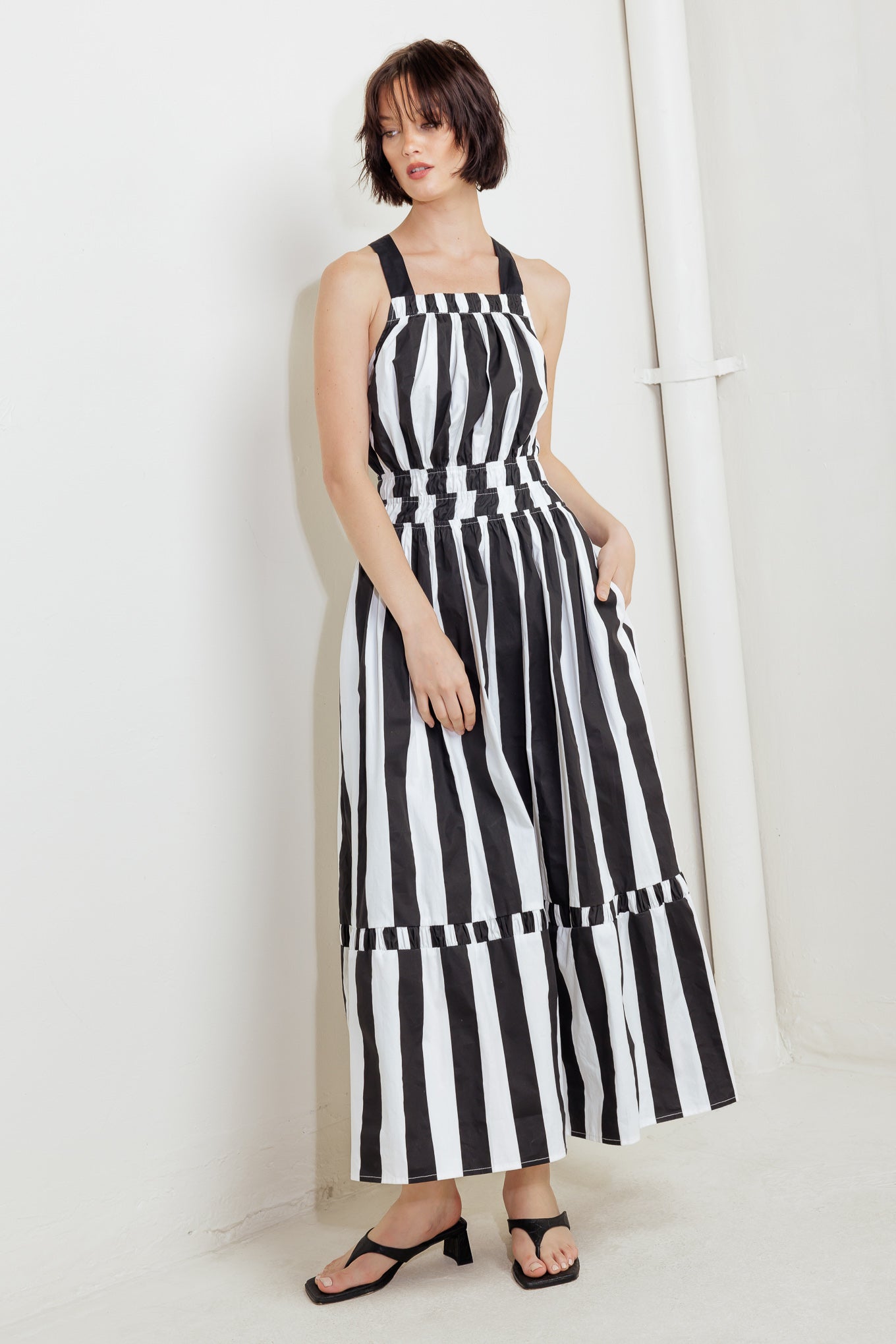 A striped woven midi dress featuring straight neckline, elasticized waist, bare back with cross strap and tie closure