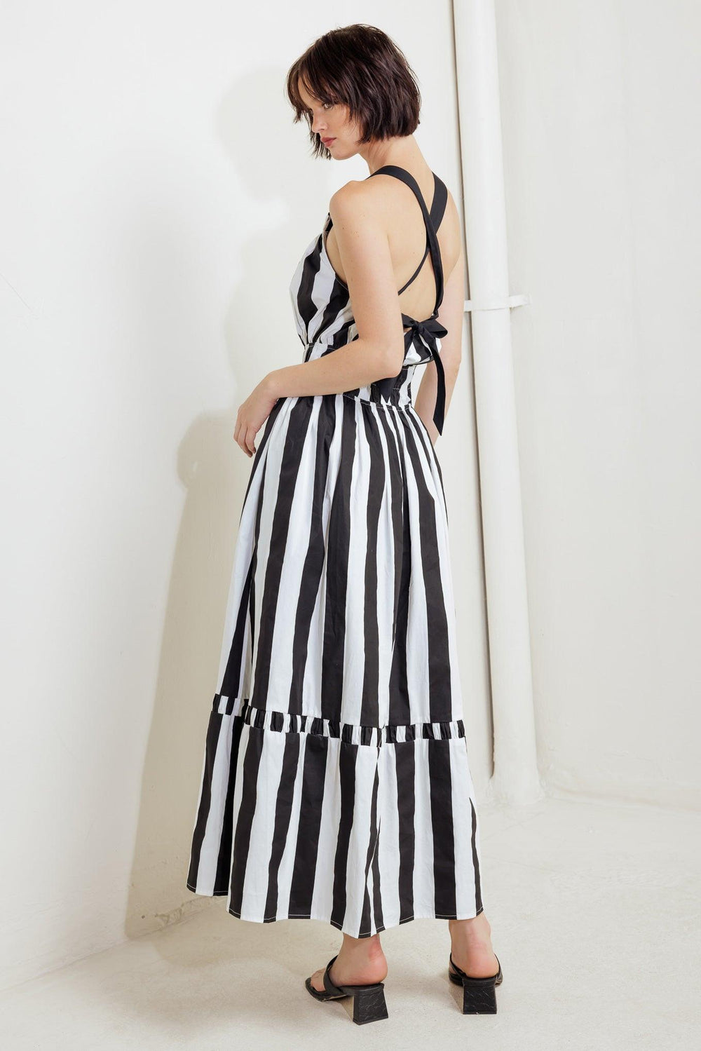 A striped woven midi dress featuring straight neckline, elasticized waist, bare back with cross strap and tie closure