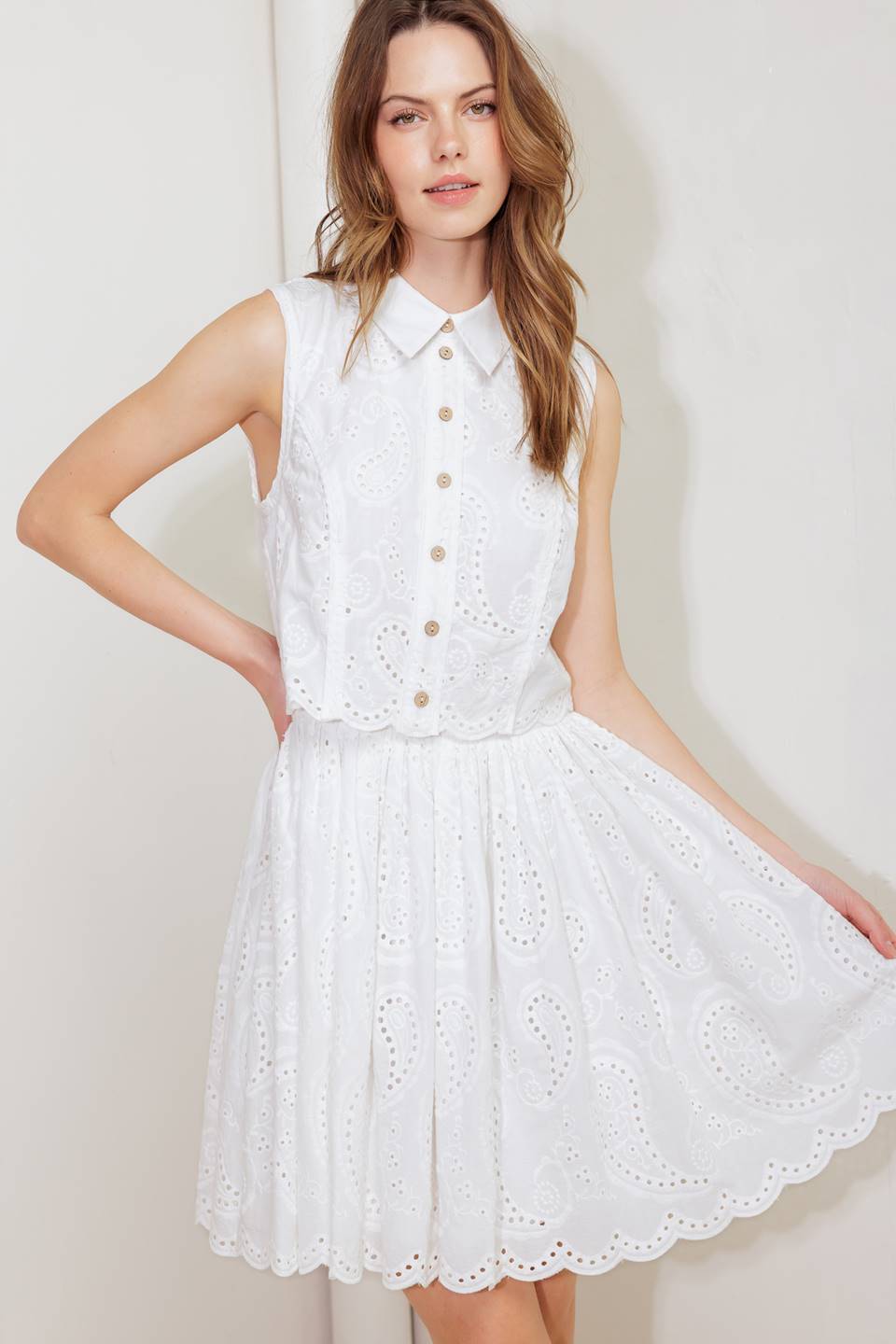 A woven eyelet mini dress featuring pop over, collar, button down, sleeveless and back zipper closure