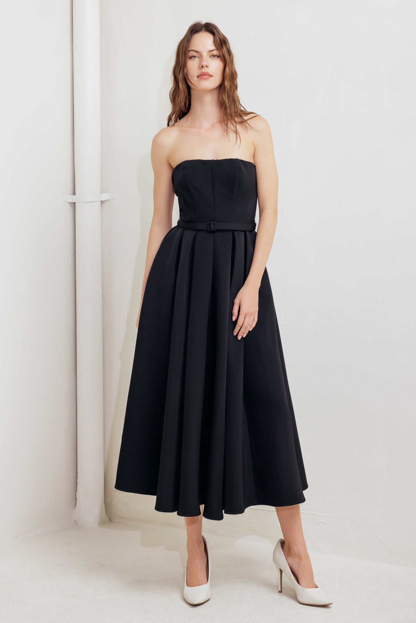 A solid woven midi dress featuring strapless straight neckline, self belt, full skirt and back zipper closure