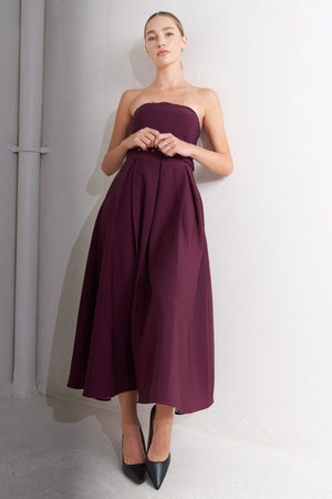 A solid woven mid dress featuring strapless, self belt, full skirt and back zipper closure