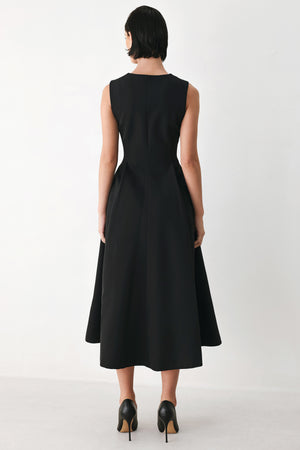 A woman modeling a sleeveless black midi dress with a prominent gold front zipper | FREEMARKET