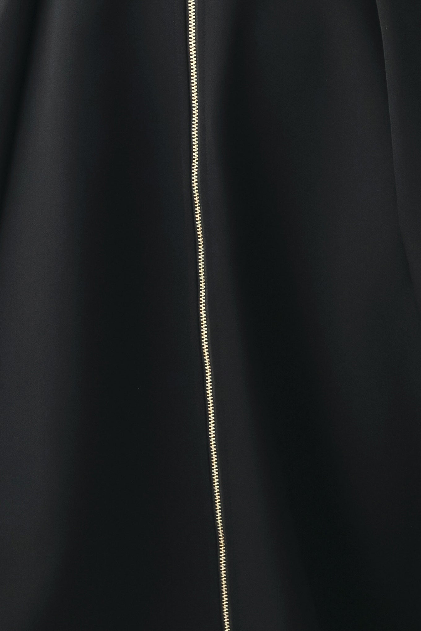 A woman modeling a sleeveless black midi dress with a prominent gold front zipper | FREEMARKET