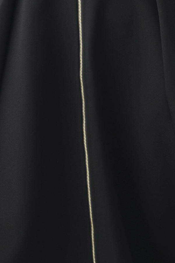 A woman modeling a sleeveless black midi dress with a prominent gold front zipper | FREEMARKET