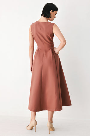 A woman modeling a sleeveless clay rose colored midi dress with a prominent gold front zipper | FREEMARKET