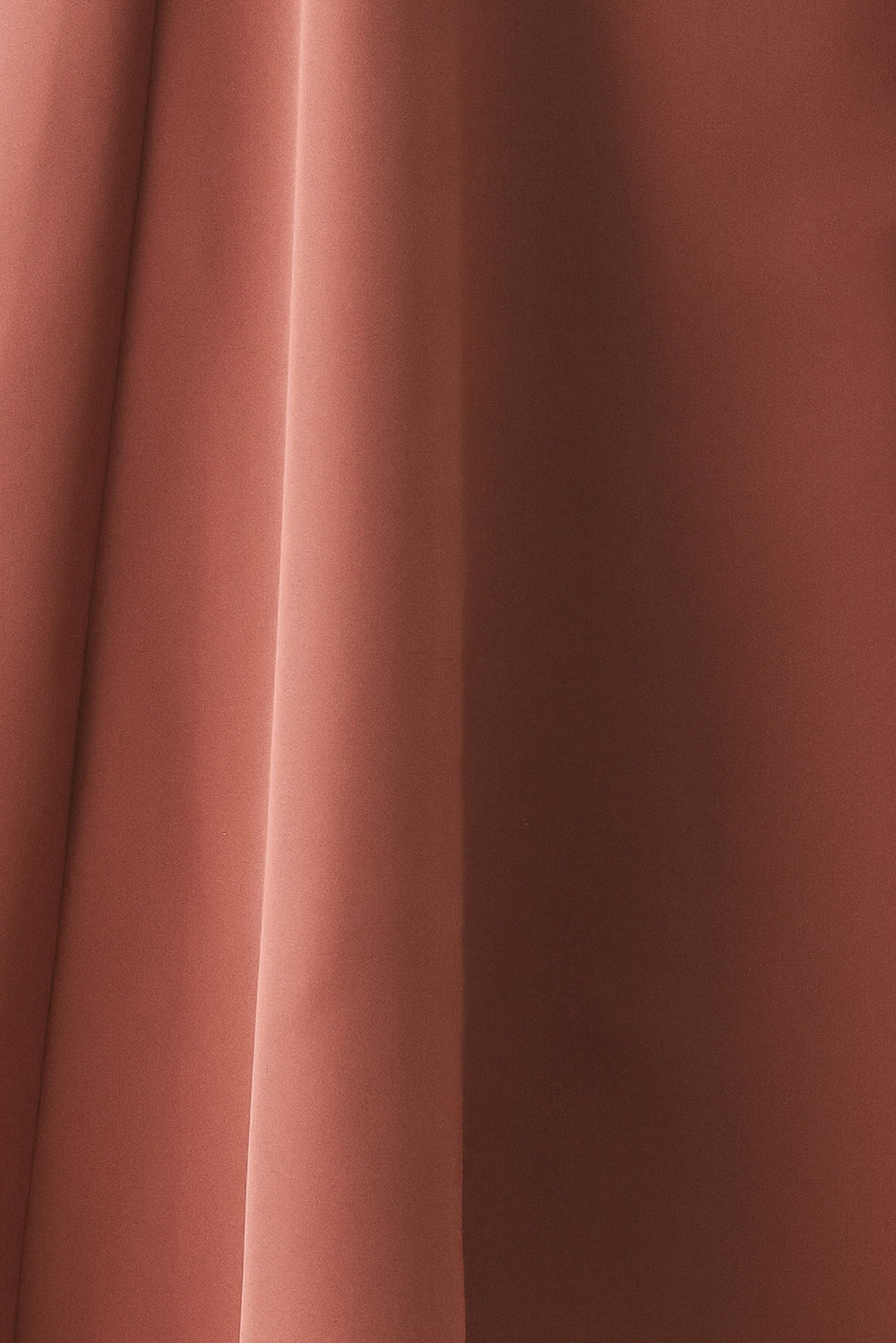 A woman modeling a sleeveless clay rose colored midi dress with a prominent gold front zipper | FREEMARKET