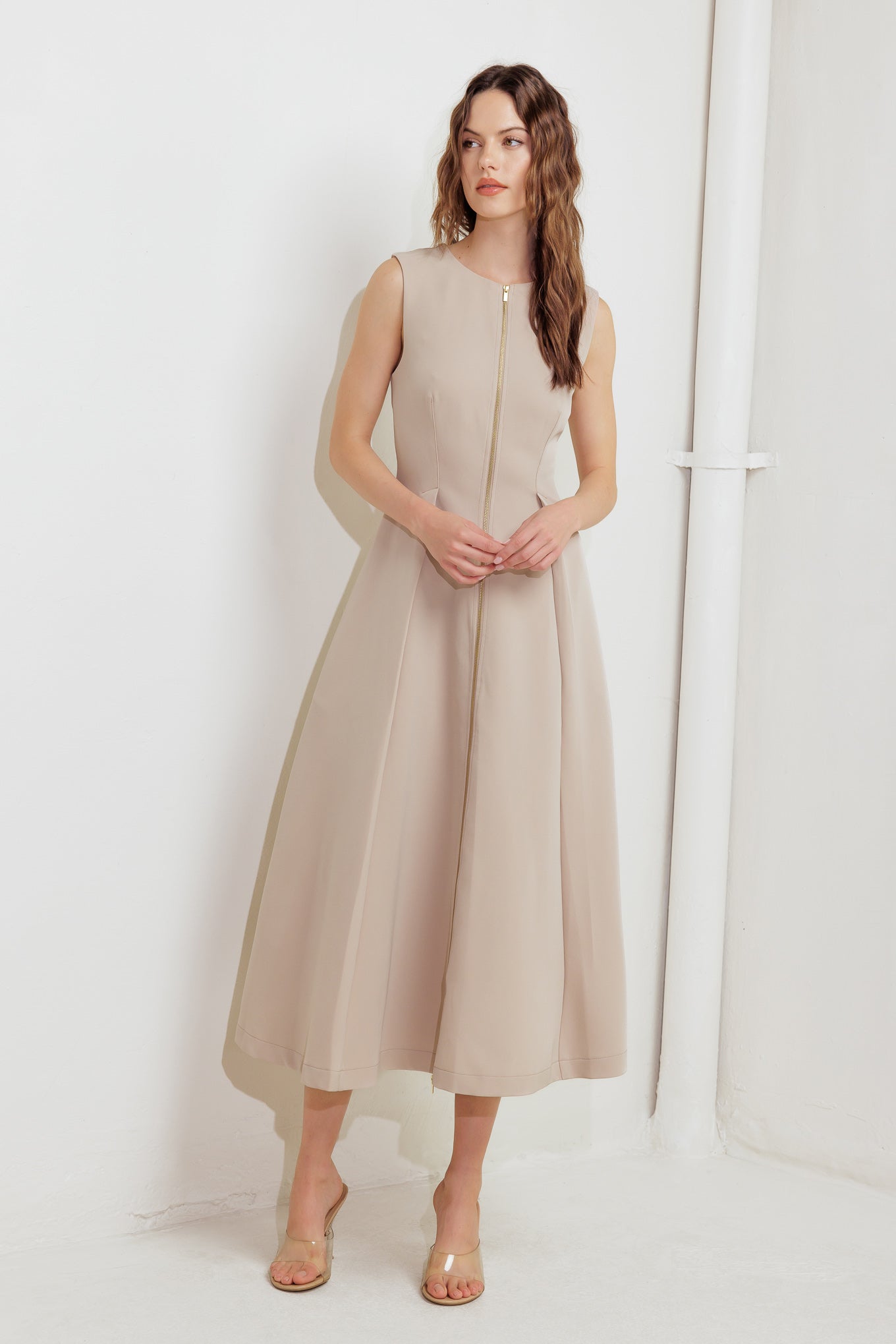 A solid woven midi dress featuring round neckline, sleeveless, front zipper closure and full skirt