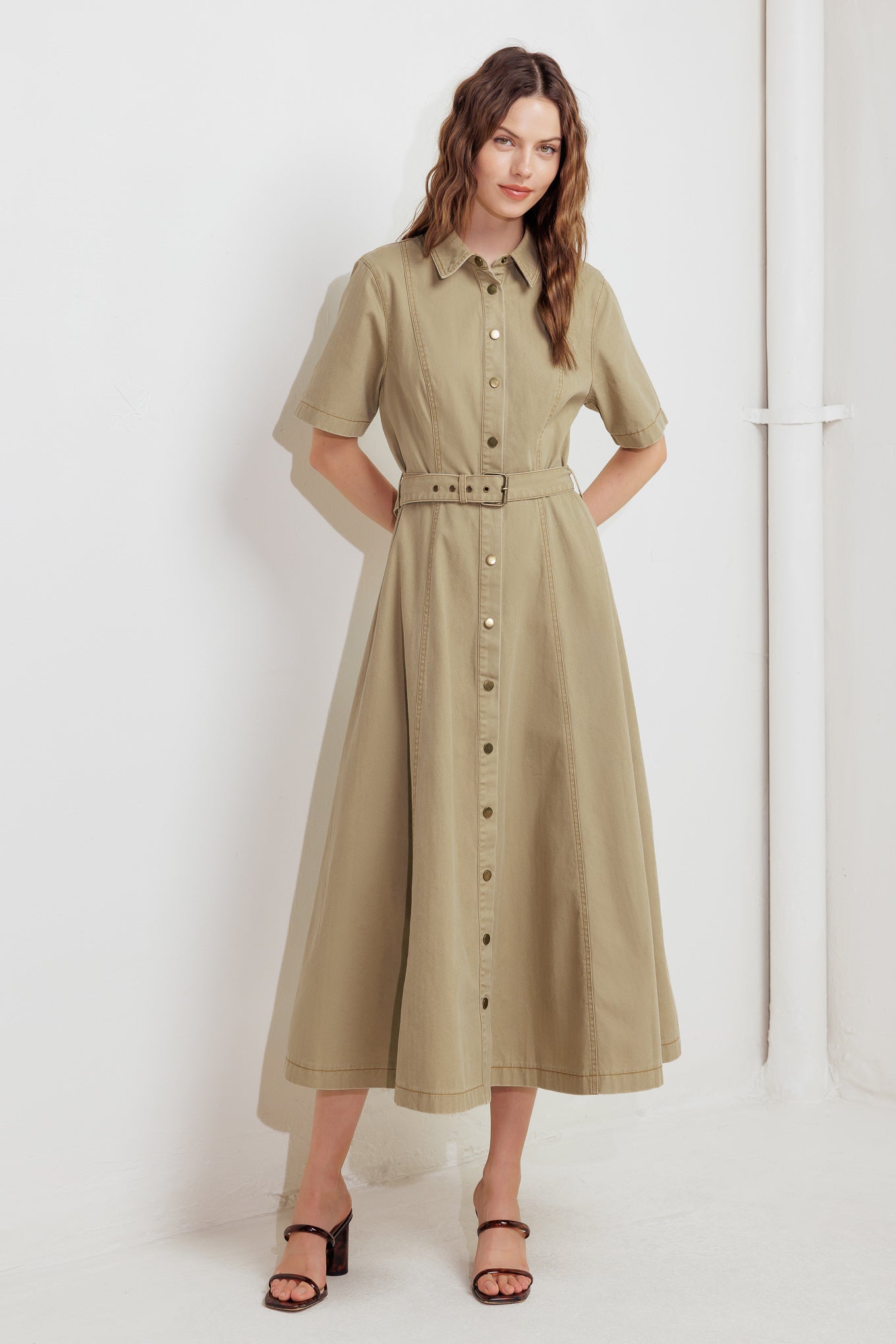 A solid woven midi dress featuring collar, short sleeve, button down, self belt and circle skirt