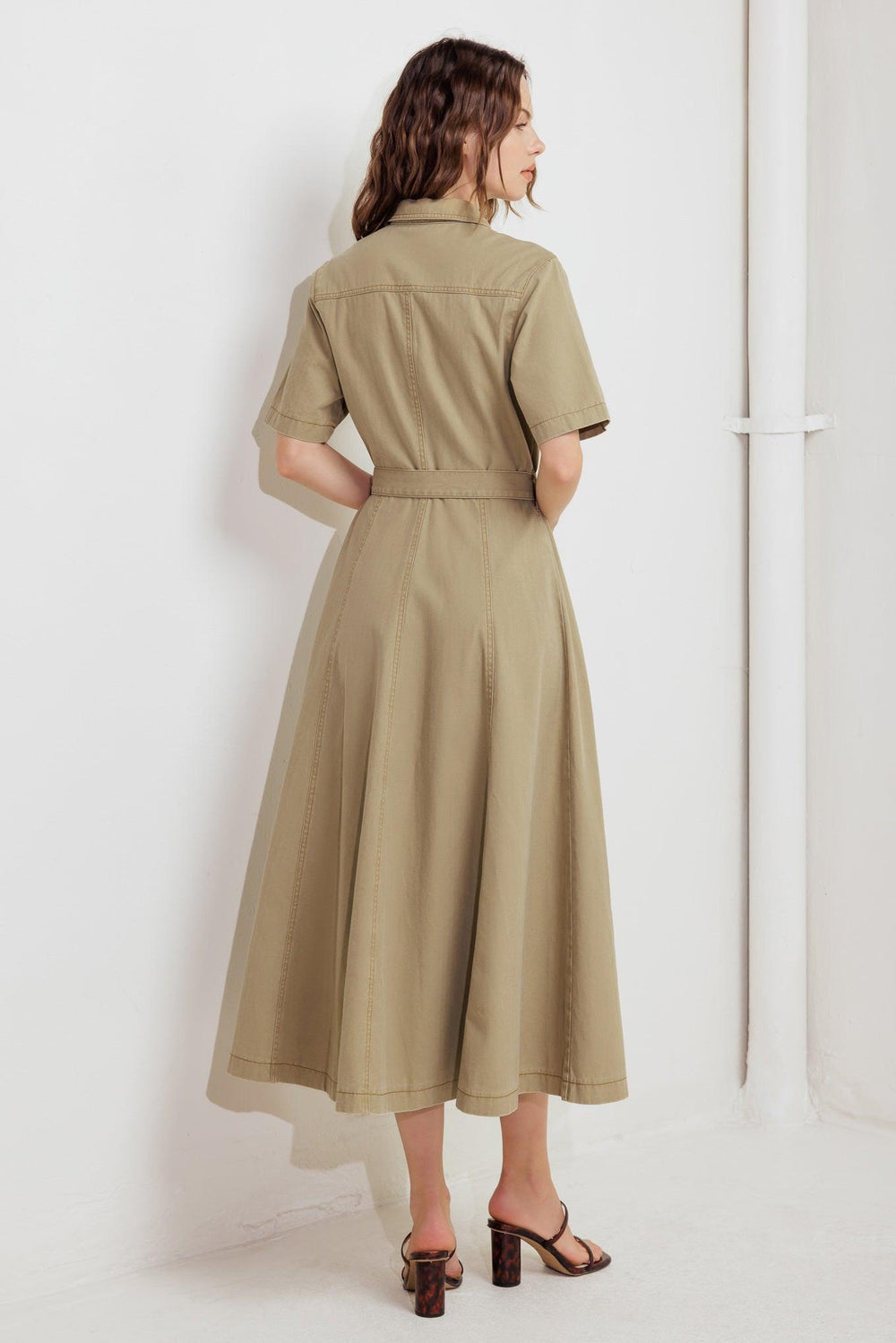 A solid woven midi dress featuring collar, short sleeve, button down, self belt and circle skirt