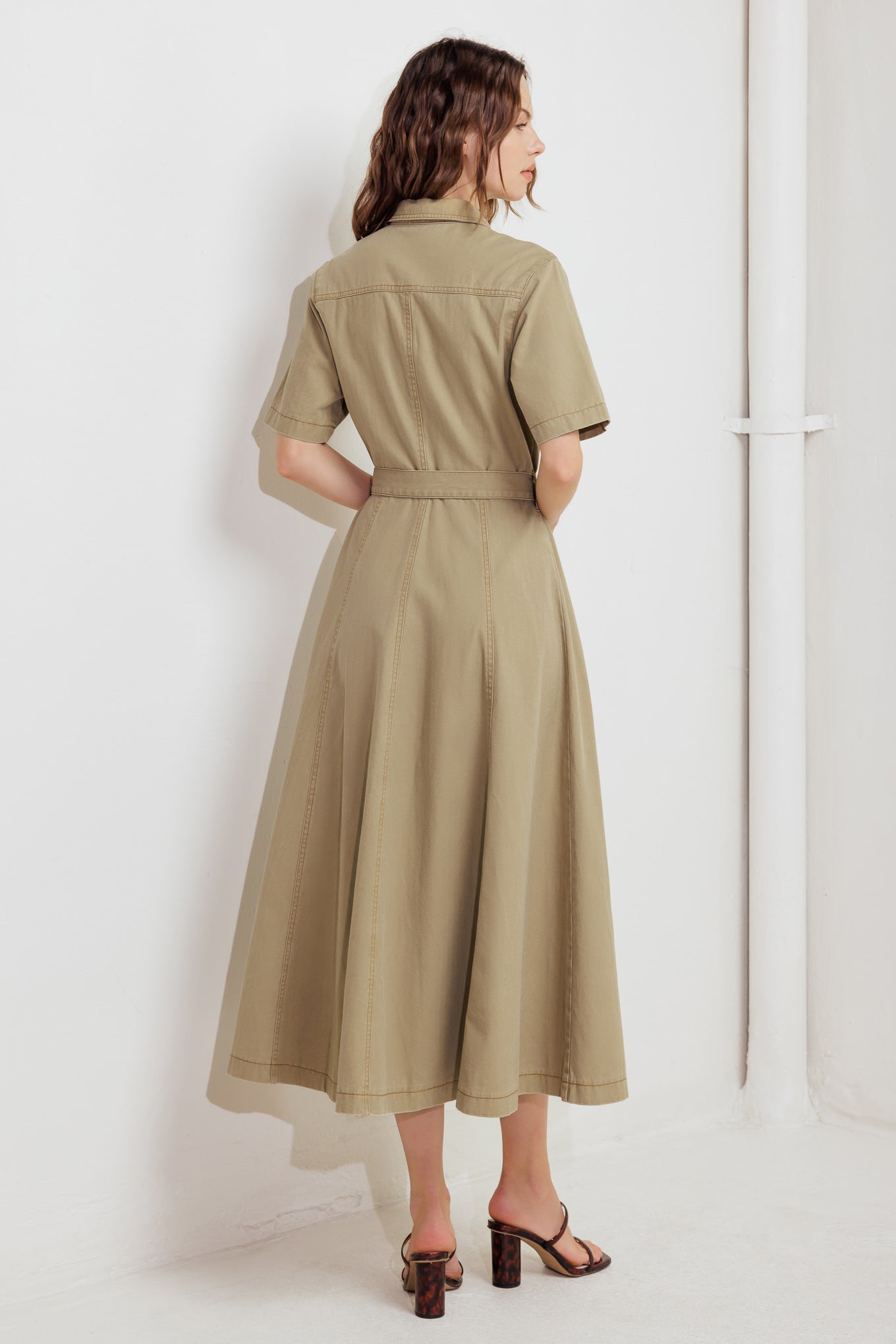 A solid woven midi dress featuring collar, short sleeve, button down, self belt and circle skirt