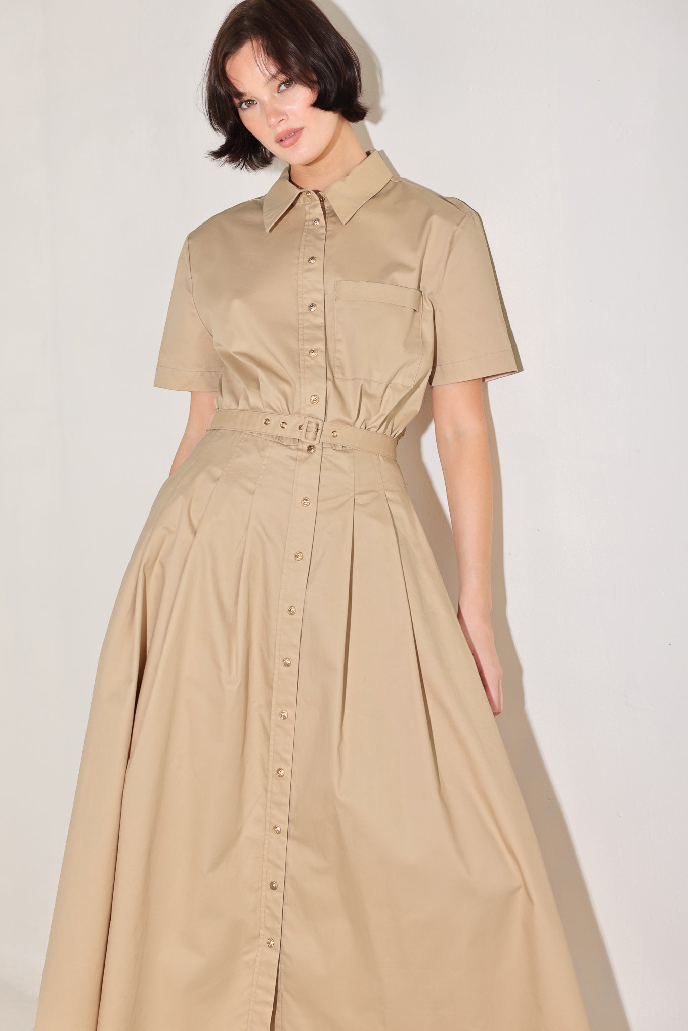 Woman wearing a beige dress with a belt on a plain background | FREEMARKET | Flying Tomato