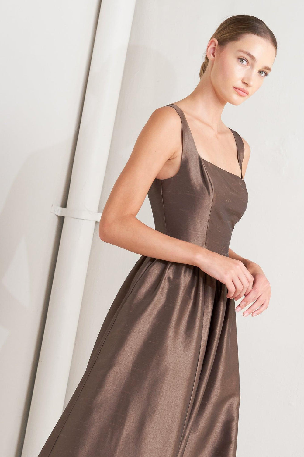 A solid woven midi dress featuring straight neckline, sleeveless, full skirt, back lace up detail and side zipper closure
