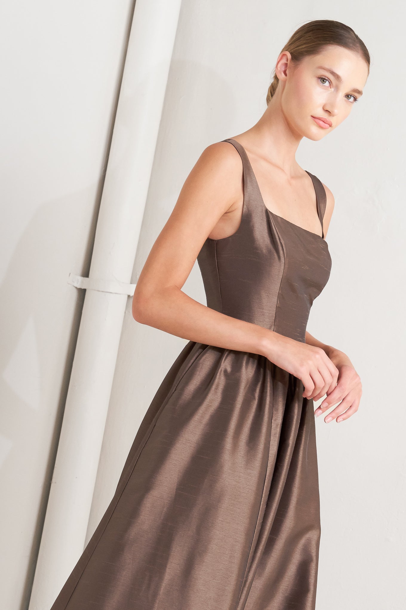 A solid woven midi dress featuring straight neckline, sleeveless, full skirt, back lace up detail and side zipper closure