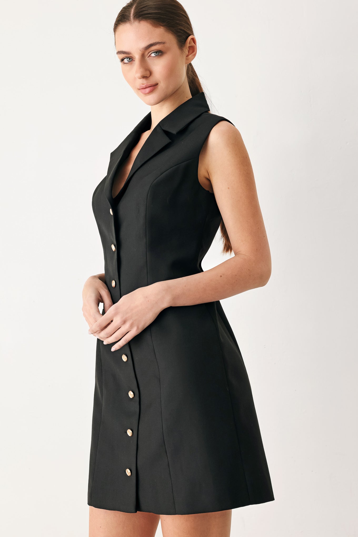 Woman wearing a black sleeveless mini dress featuring blazer collar and front button down | FREEMARKET