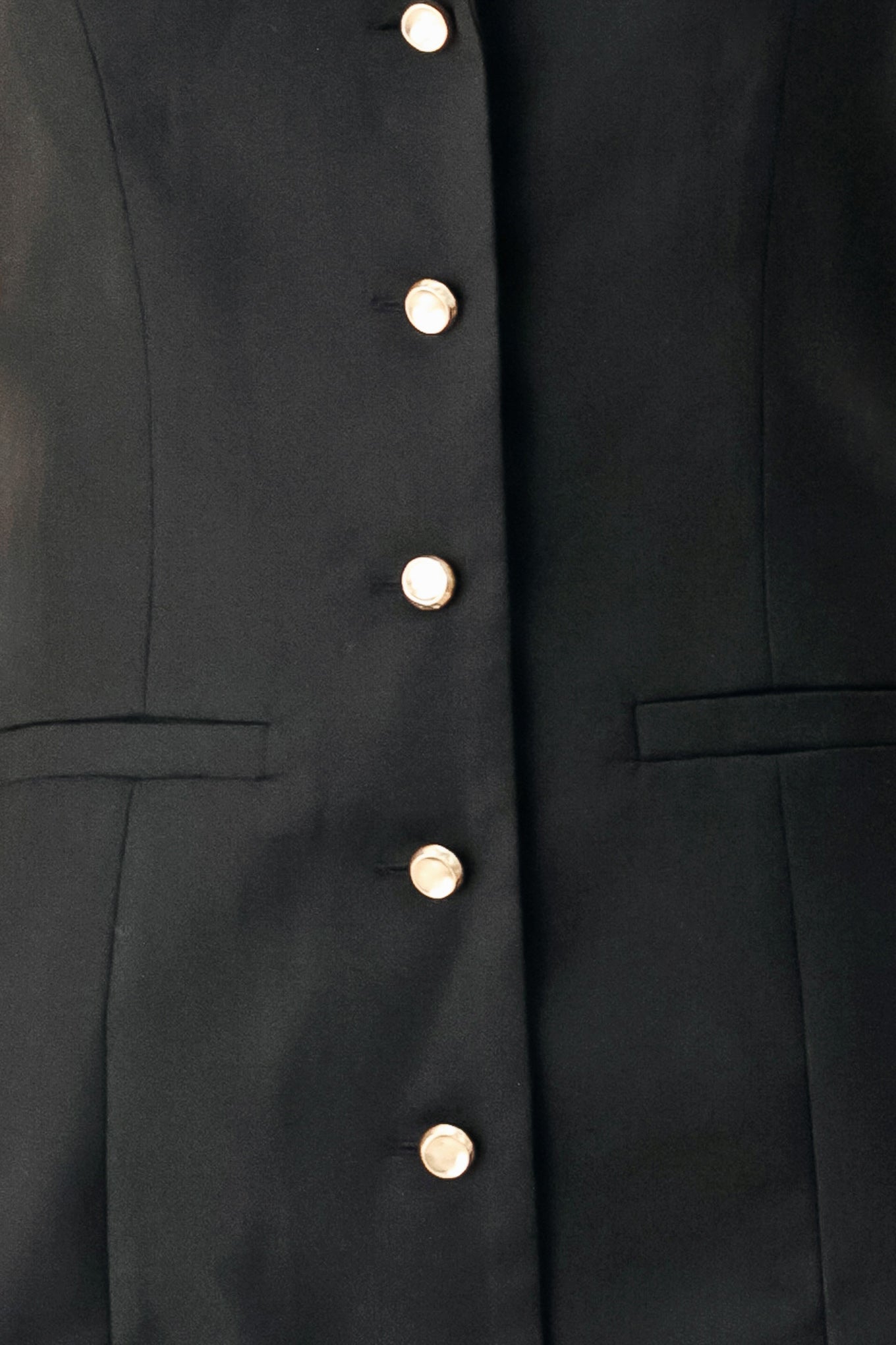 Woman wearing a black sleeveless mini dress featuring blazer collar and front button down | FREEMARKET
