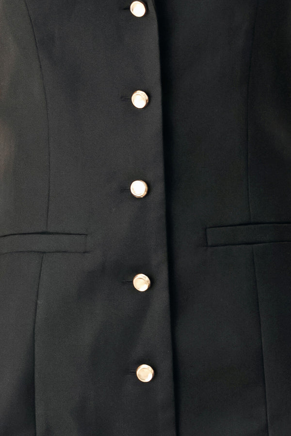 Woman wearing a black sleeveless mini dress featuring blazer collar and front button down | FREEMARKET