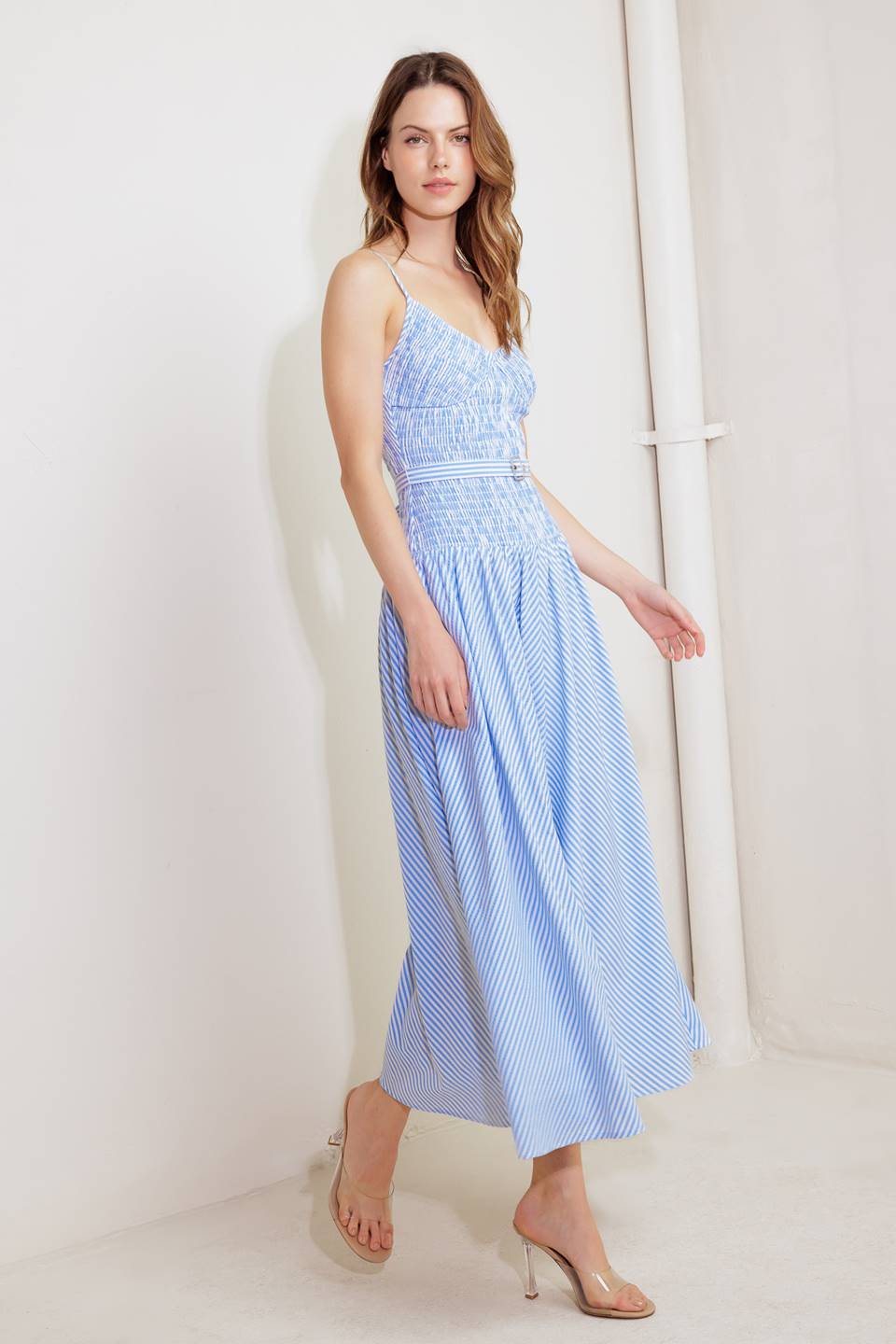 A striped woven midi dress featuring V neckline, straps, smocked bodice self belt and full skirt