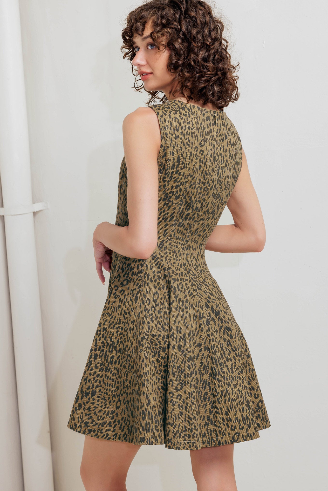 A printed woven mini dress featuring round neckline, sleeveless, circle skirt and back zipper closure