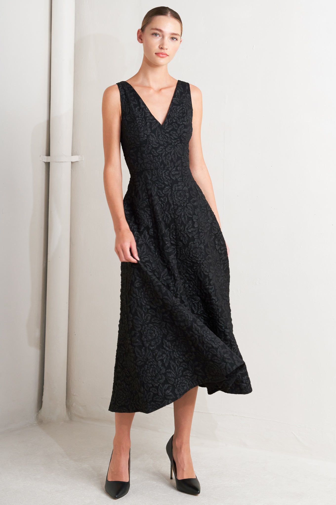 A jacquard woven midi dress featuring V neckline, sleeveless with back strap, circle skirt and back zipper closure