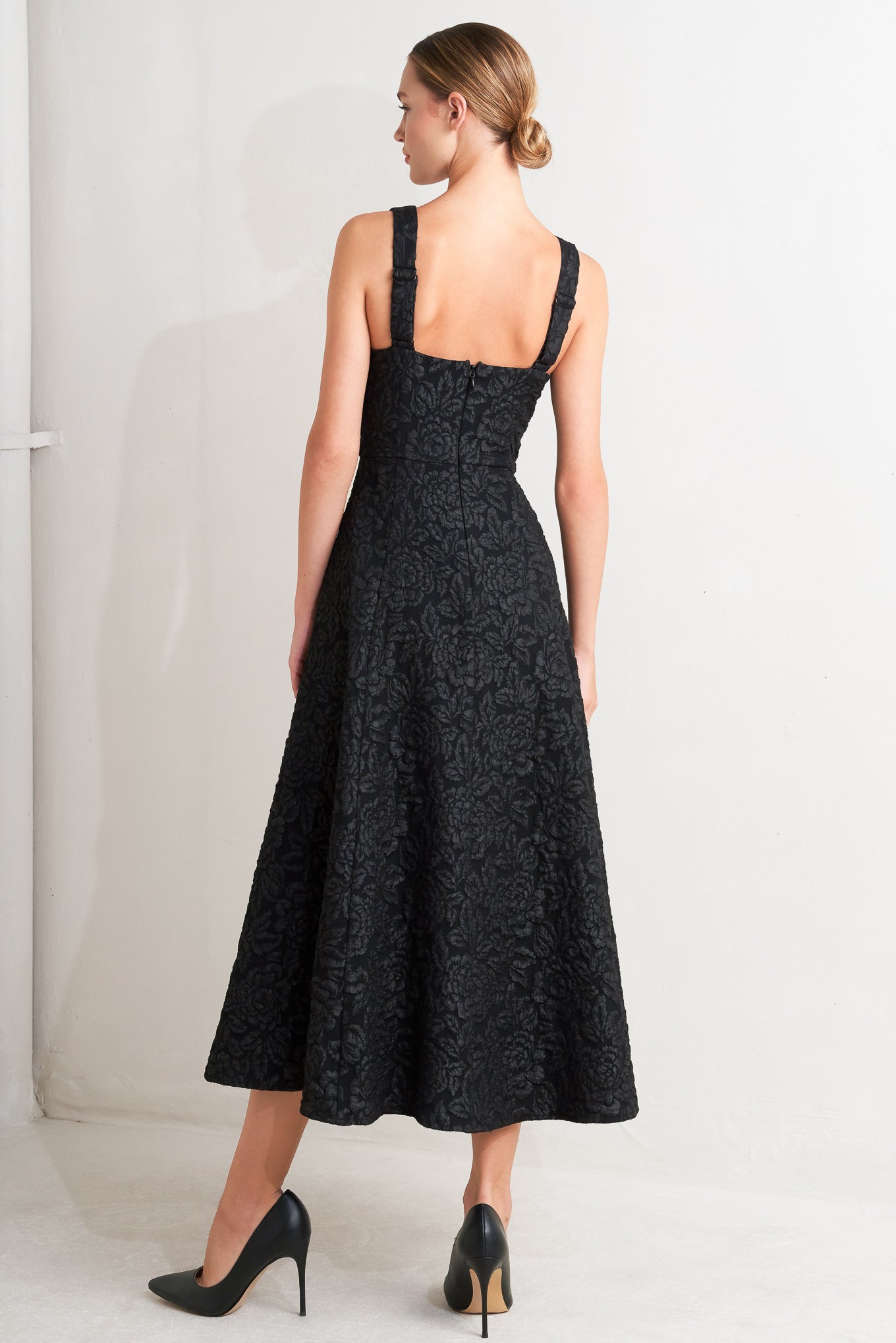 A jacquard woven midi dress featuring V neckline, sleeveless with back strap, circle skirt and back zipper closure