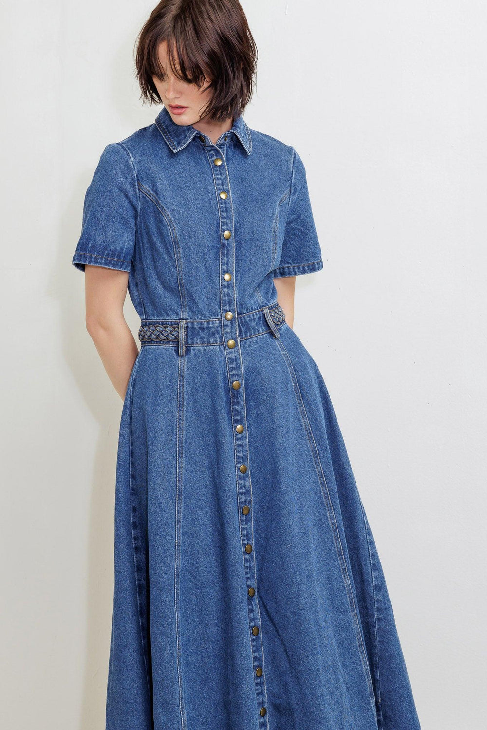 A washed denim midi dress featuring collar, short sleeve, button down, braided waistband and circle skirt