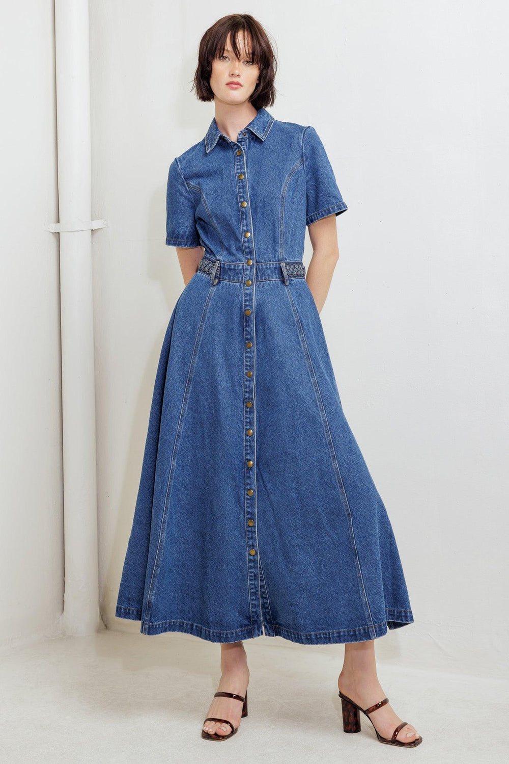A washed denim midi dress featuring collar, short sleeve, button down, braided waistband and circle skirt