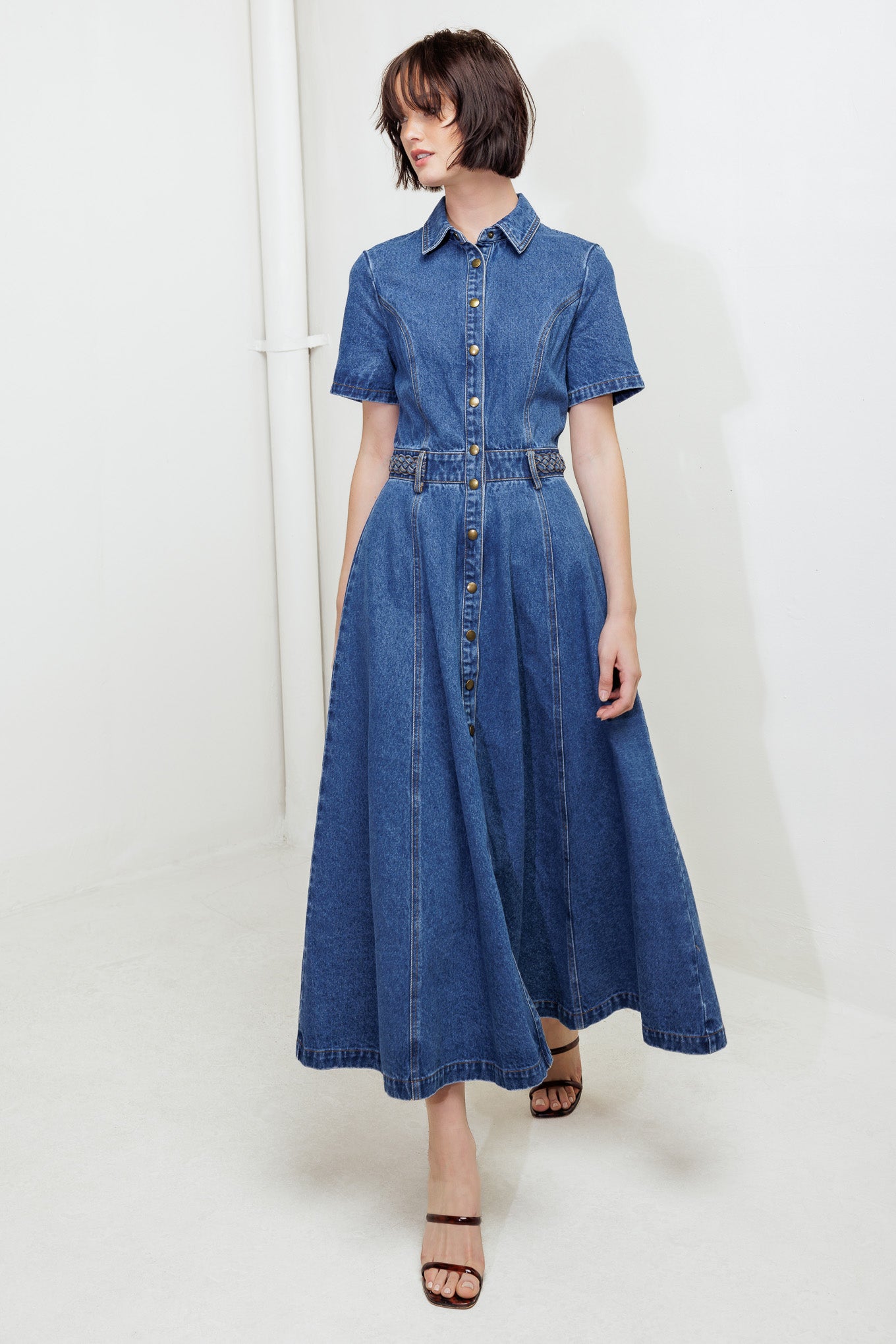 A washed denim midi dress featuring collar, short sleeve, button down, braided waistband and circle skirt