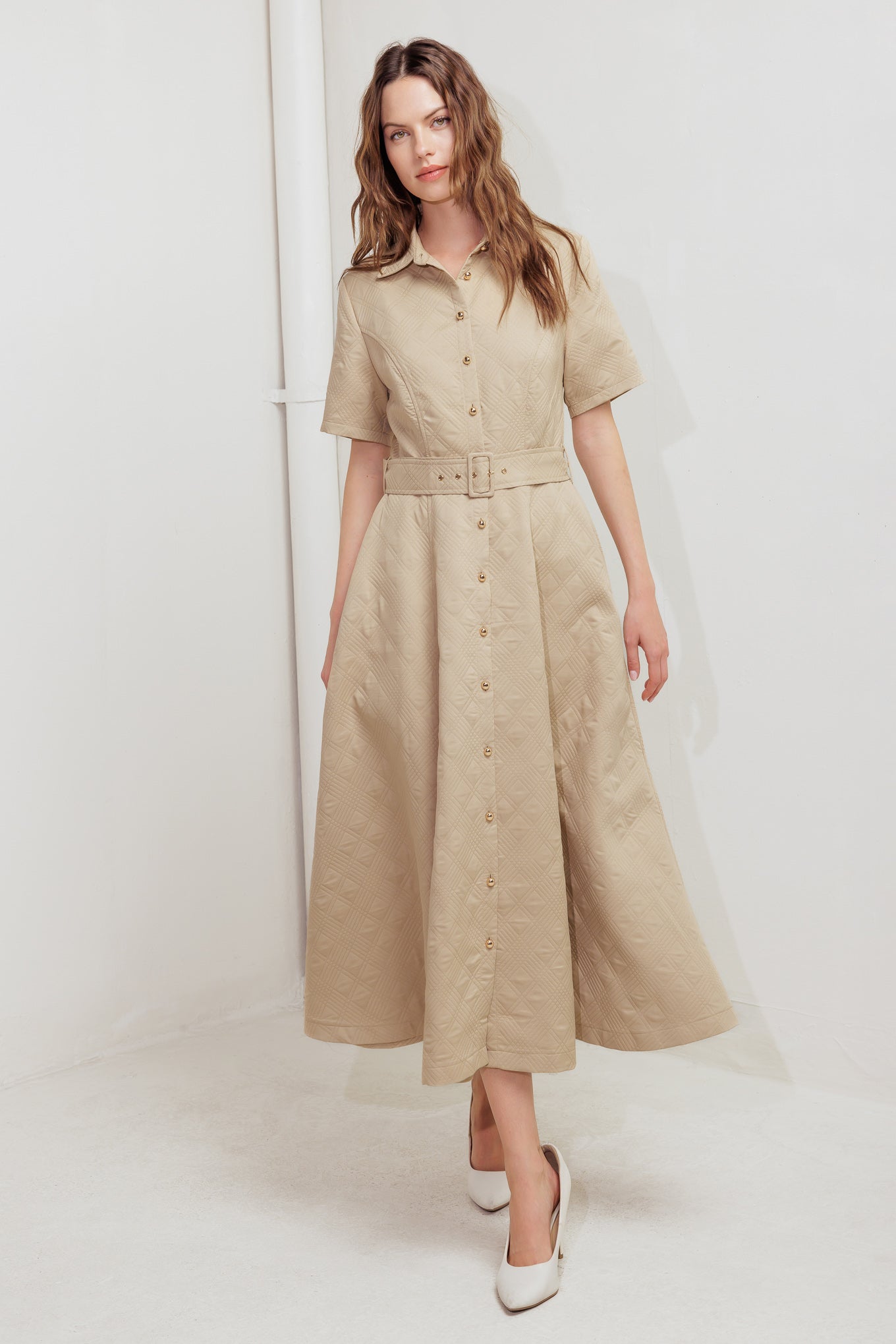 A textured woven midi dress featuring a collar, short sleeve, button down, self belt and circle skirt