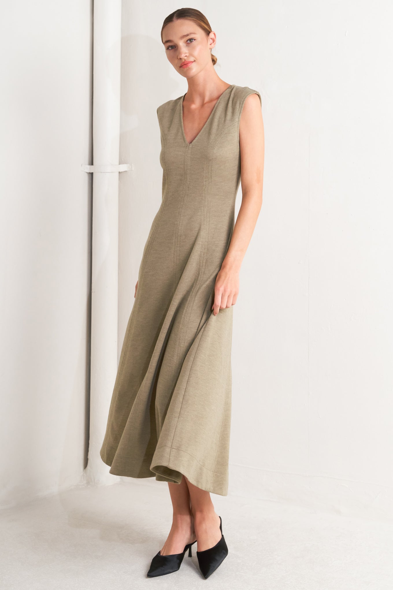 A woven knit midi dress featuring V neckline, sleeveless, circle skirt and back zipper closure