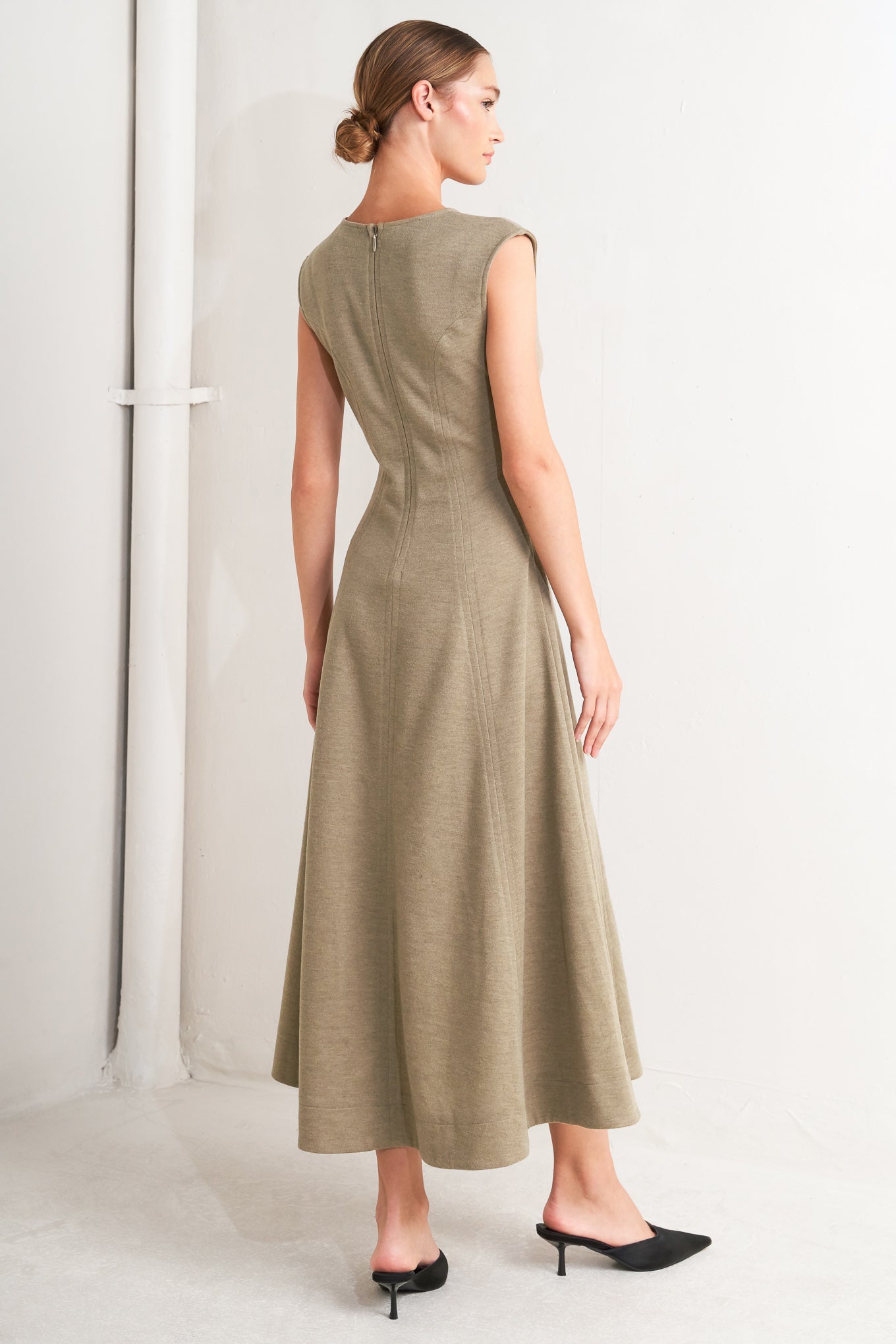 A woven knit midi dress featuring V neckline, sleeveless, circle skirt and back zipper closure