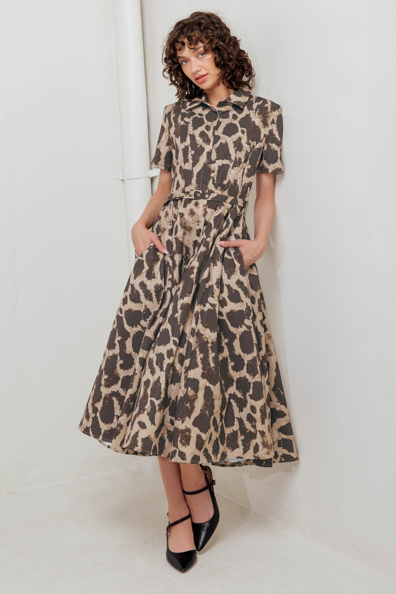 A printed woven midi dress featuring collar, short sleeve, hidden placket with button, self belt and circle skirt