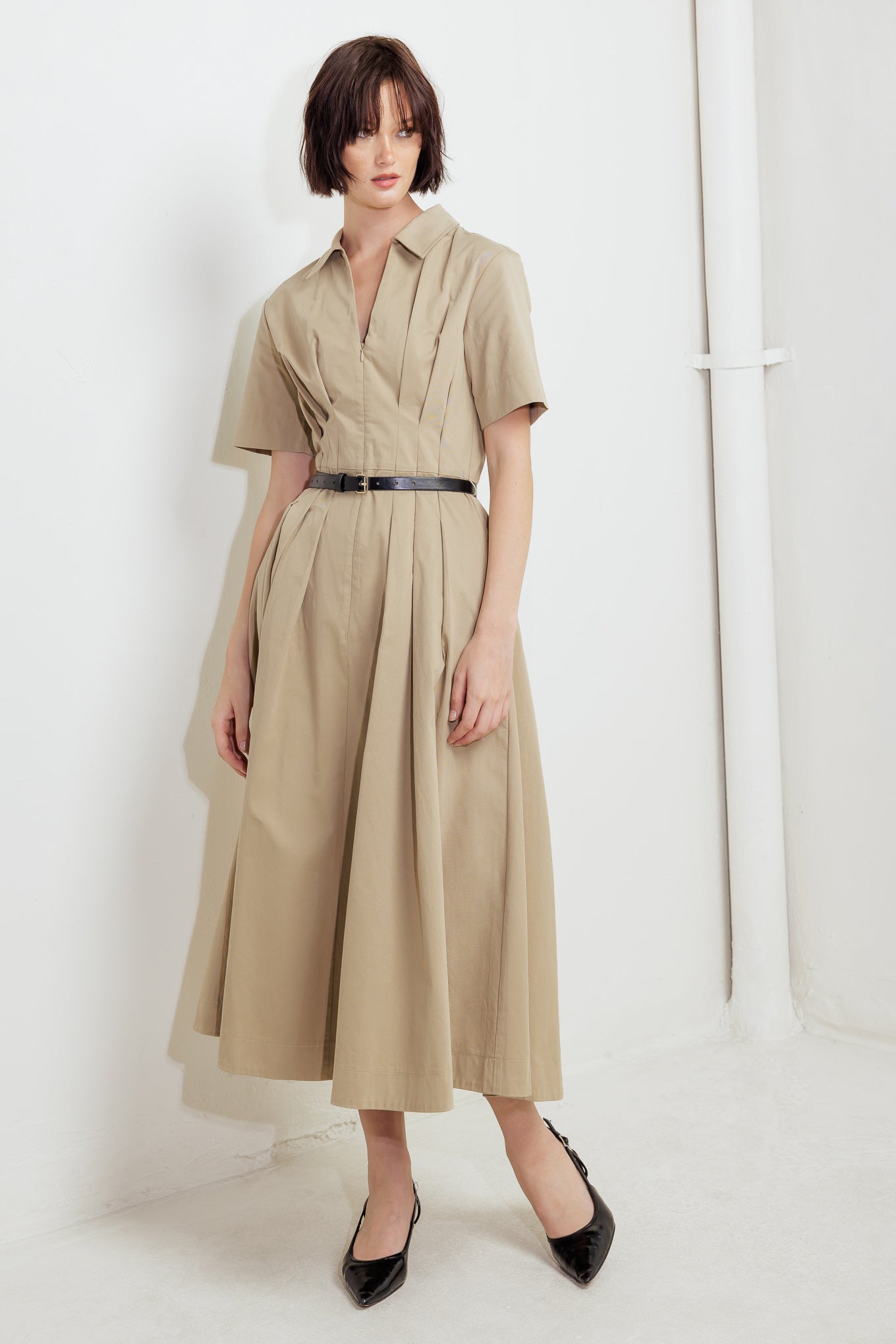 A solid woven midi dress featuring collar, short sleeve, front zipper closure, contrasting belt and full skirt