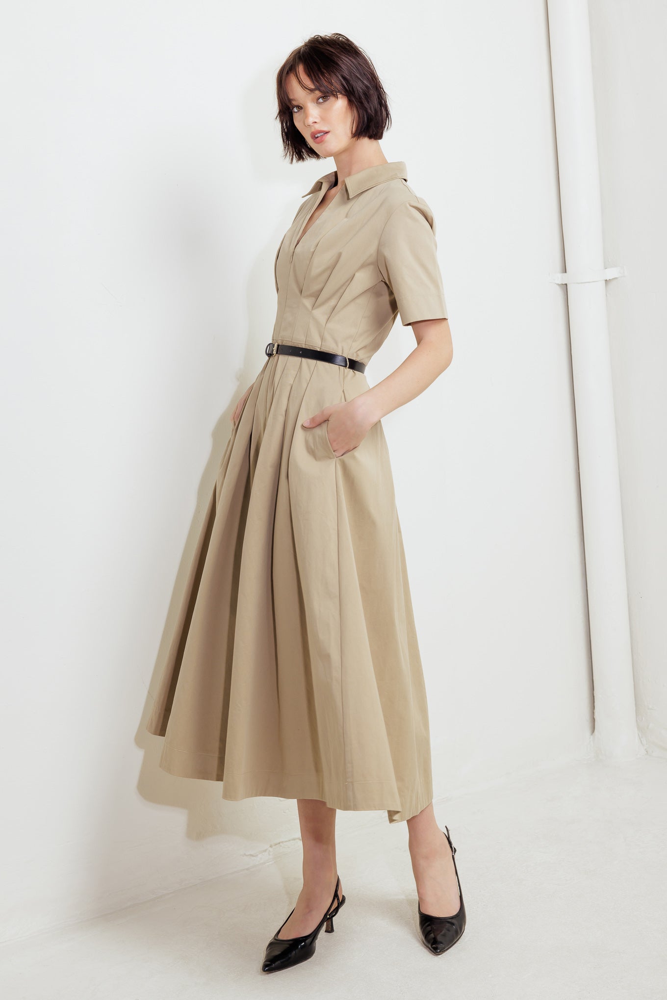 A solid woven midi dress featuring collar, short sleeve, front zipper closure, contrasting belt and full skirt