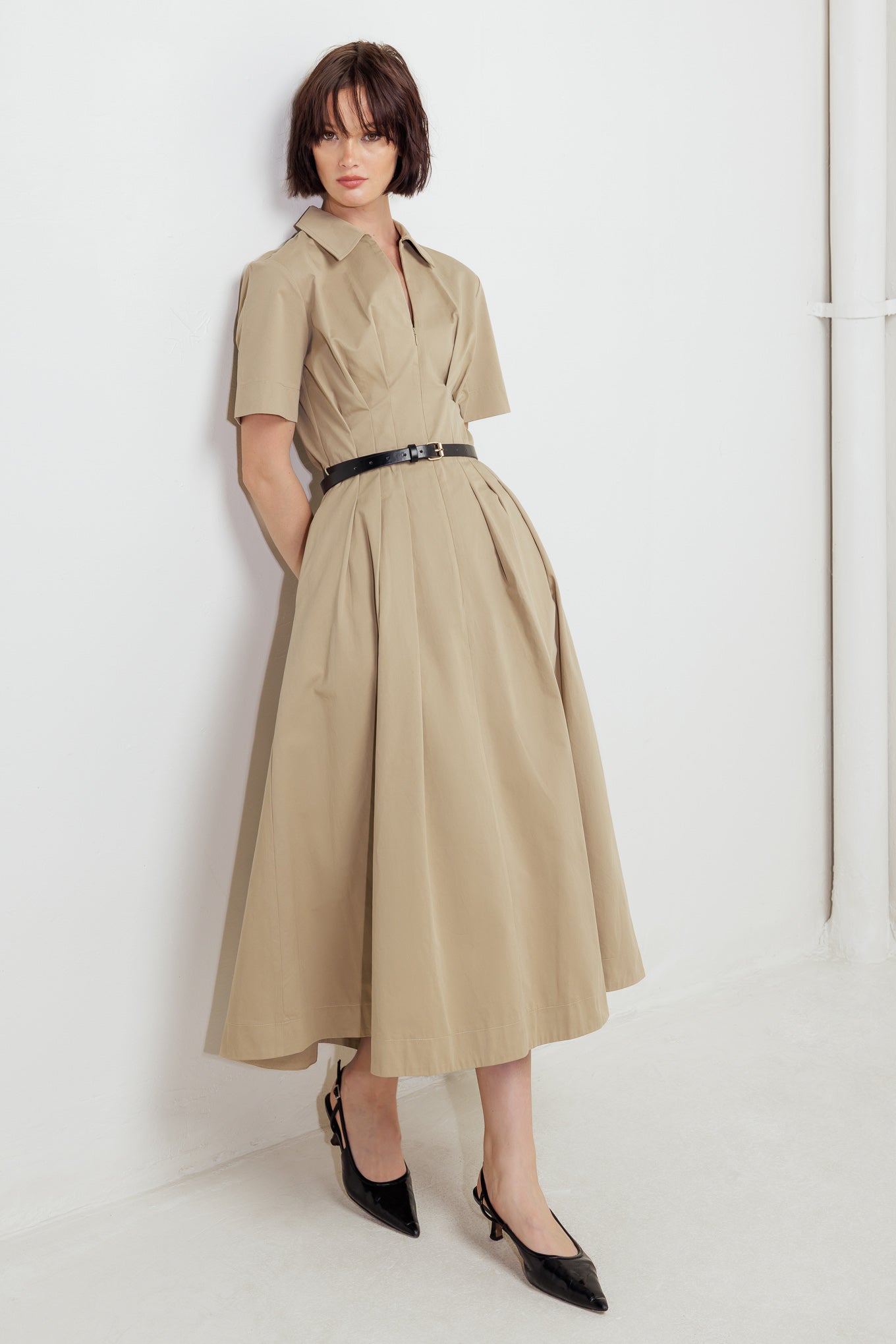 A solid woven midi dress featuring collar, short sleeve, front zipper closure, contrasting belt and full skirt