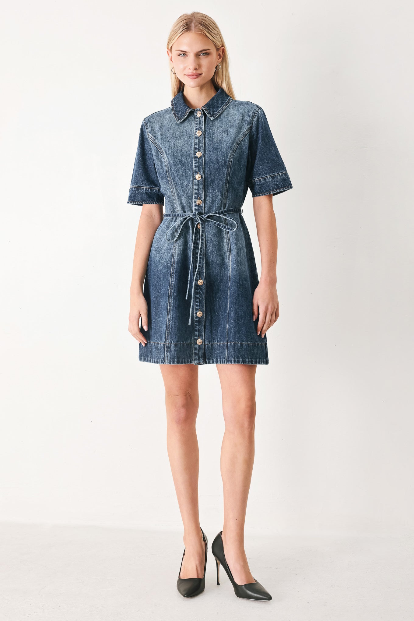 Woman wearing a denim mini dress featuring front button down, short sleeve and skinny waist tie | FREEMARKET