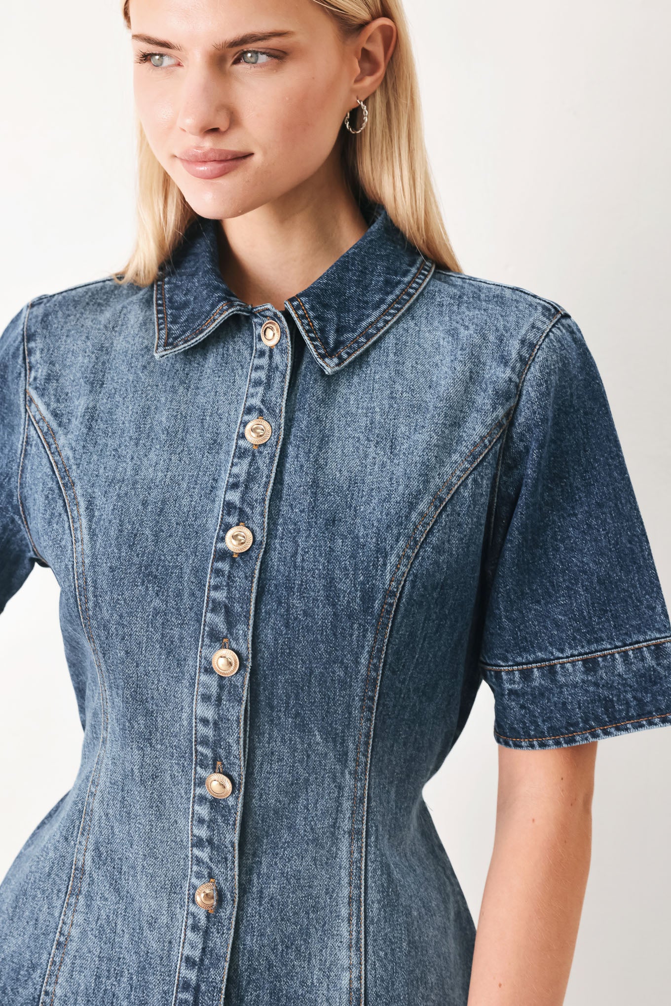 Woman wearing a denim mini dress featuring front button down, short sleeve and skinny waist tie | FREEMARKET