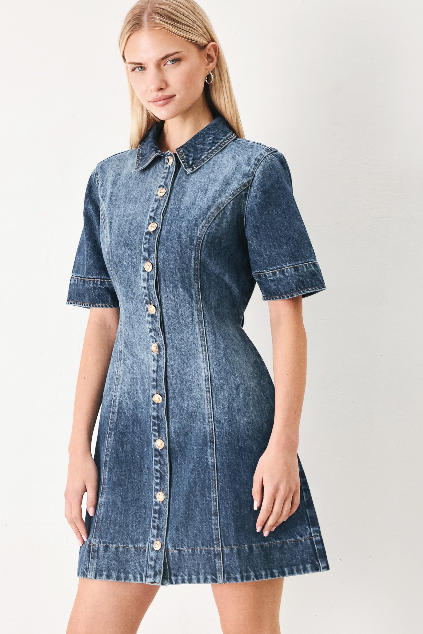Woman wearing a denim mini dress featuring front button down, short sleeve and skinny waist tie | FREEMARKET