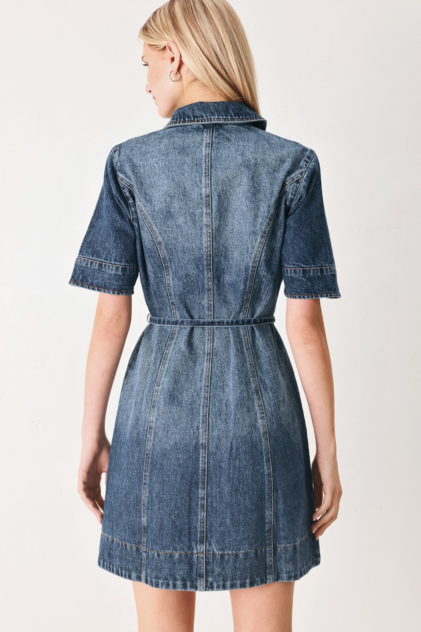 Woman wearing a denim mini dress featuring front button down, short sleeve and skinny waist tie | FREEMARKET