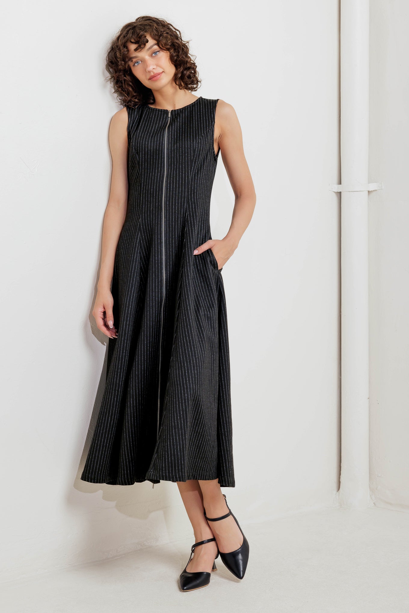 A striped woven midi dress featuring round neckline, sleeveless, circle skirt and front zipper closure