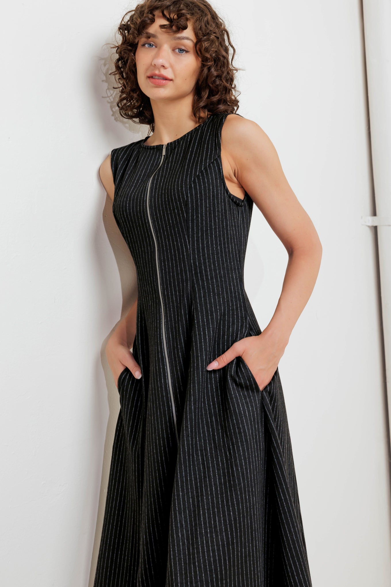 A striped woven midi dress featuring round neckline, sleeveless, circle skirt and front zipper closure