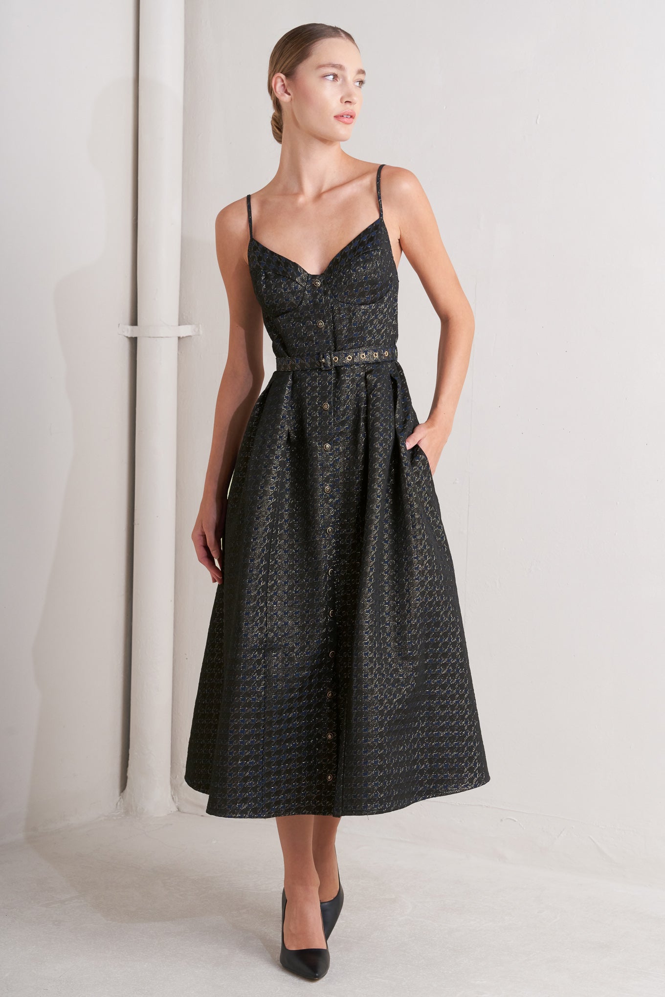 A textured woven midi dress featuring cami top with straps, self belt, full skirt and front button down closure