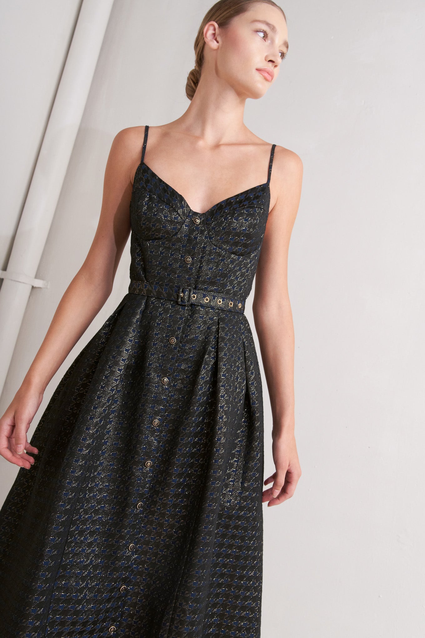 A textured woven midi dress featuring cami top with straps, self belt, full skirt and front button down closure