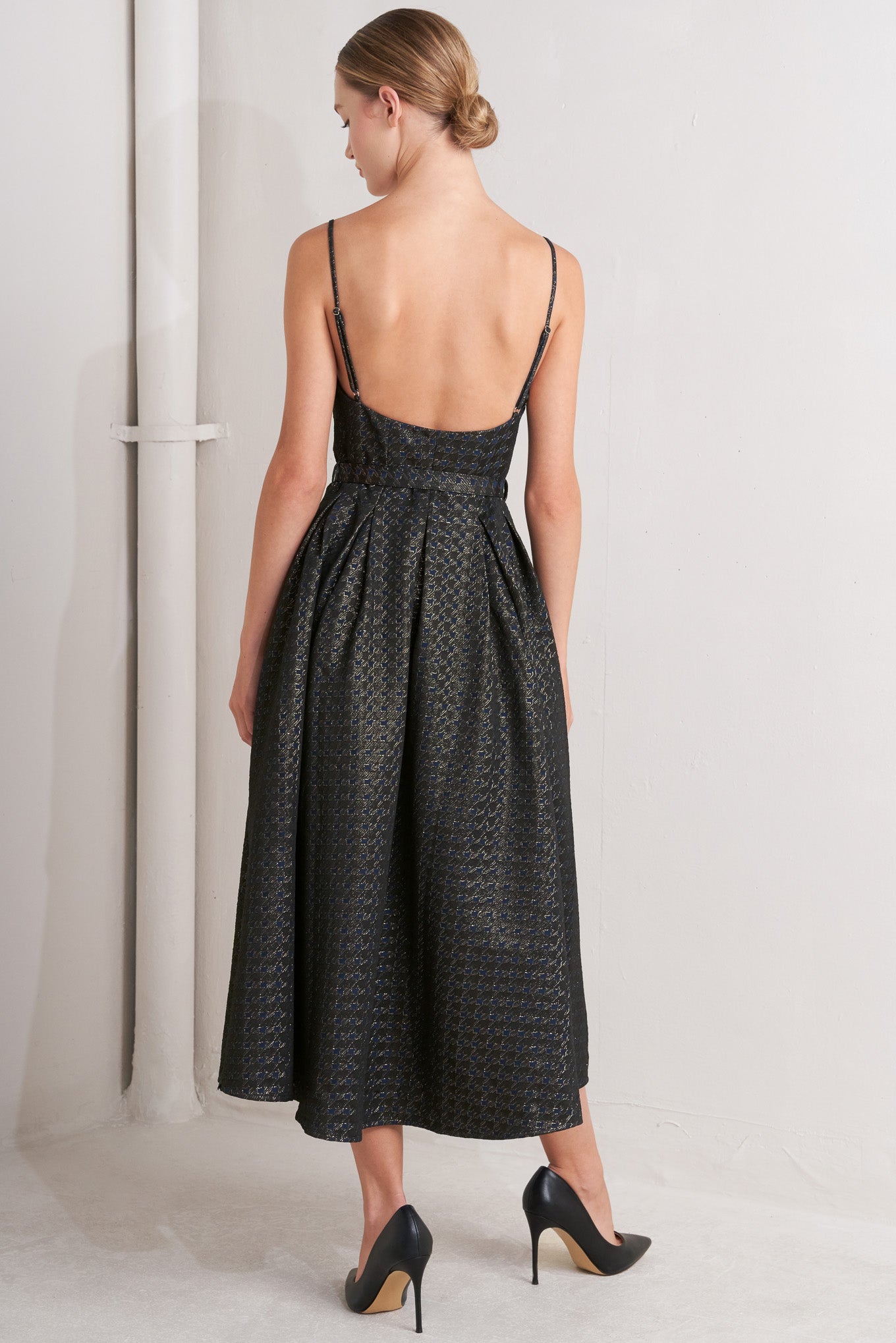 A textured woven midi dress featuring cami top with straps, self belt, full skirt and front button down closure