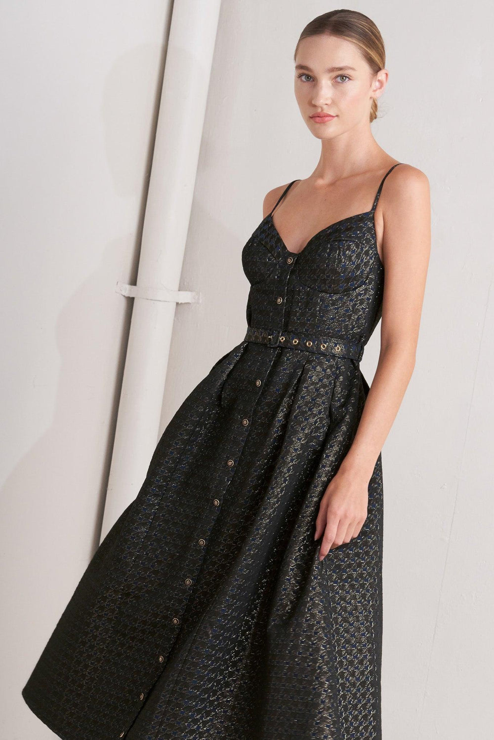A textured woven midi dress featuring cami top with straps, self belt, full skirt and front button down closure
